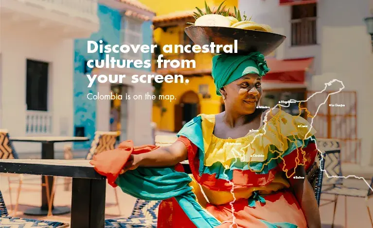 Woman wearing traditional dress and carrying fruit on her head on a street on the Caribbean coast