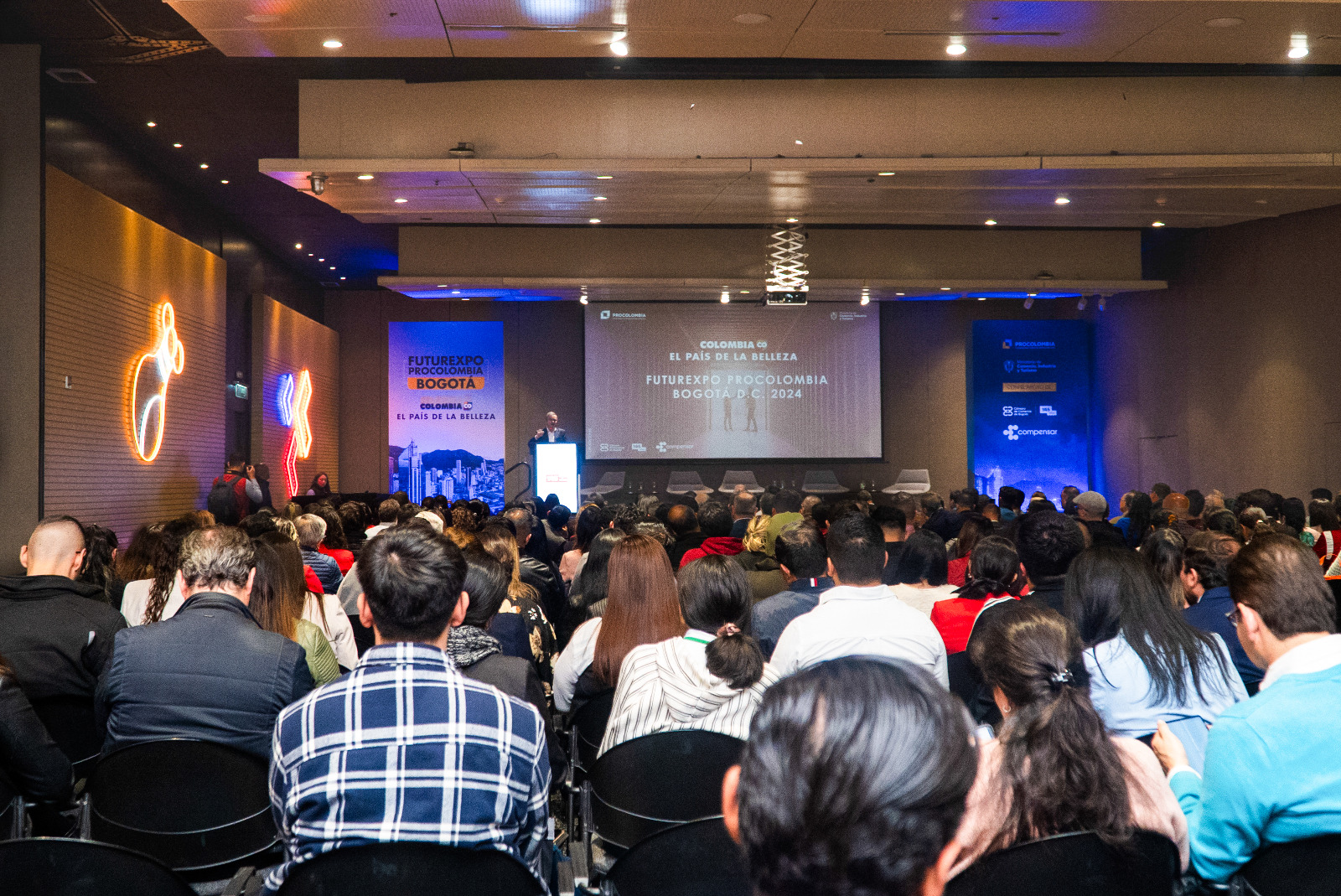 Un auditorio lleno de asistentes prestando atención a una conferencia de Futurexpo