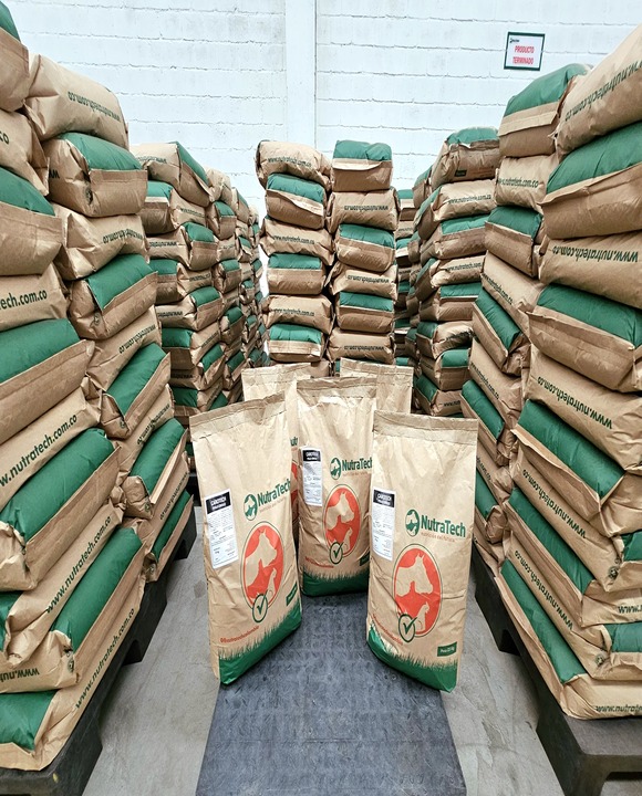 Una bodega con sacos apilados de alimento para animales de la marca NutraTech,