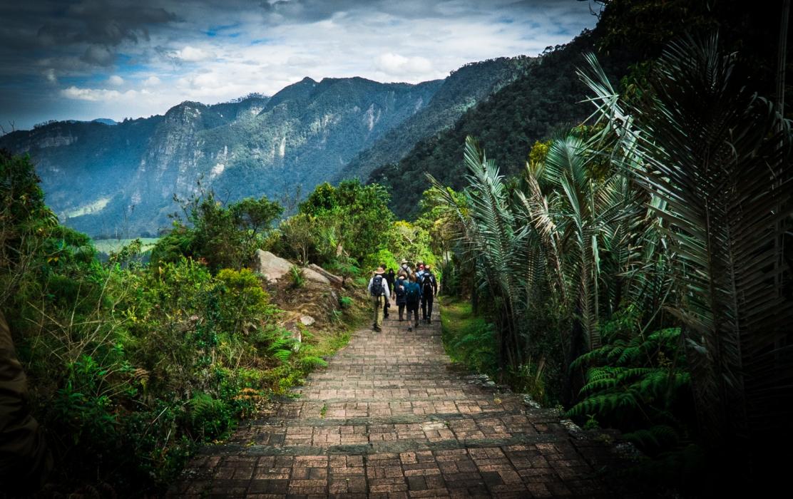Paisaje con montañas en Colombia y turistas caminando por un sendero