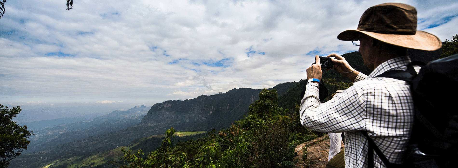 Turista fotografiando paisaje con montañas en Colombia