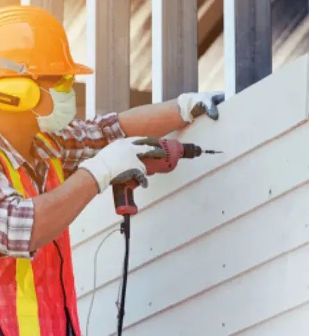 Trabajador construyendo edificio con materiales de construcción colombianos.