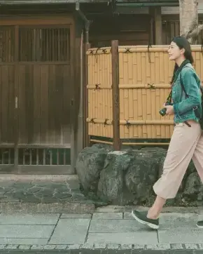 Mujer caminando en frente de casa asiática