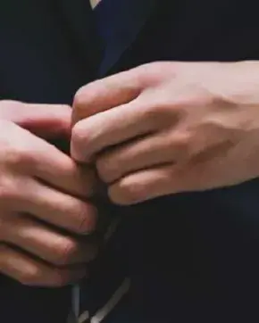 Ejecutivo colocándose el botón del traje