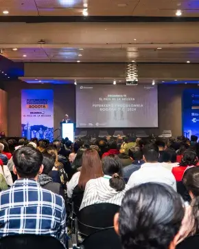 Un auditorio lleno de asistentes prestando atención a una conferencia de Futurexpo