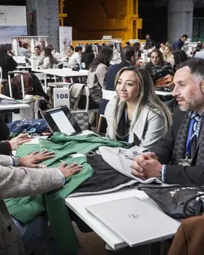 Grupo de personas hablando en una mesa en stand de feria sobre Macrorruedas