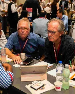 Grupo de personas en una mesa escuchando a un capacitador