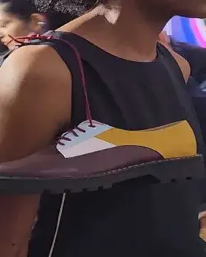 Persona con un par de zapatos en el el hombro