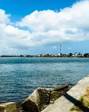 Fotografía panorámica del mar con ciudad al fondo