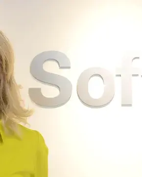 Fotografía de mujer con el letrero de la multinacional Sofftek