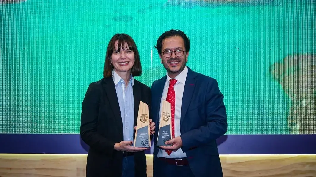 Fotografía a dos representantes para la premiación de los mejores destinos del mundo