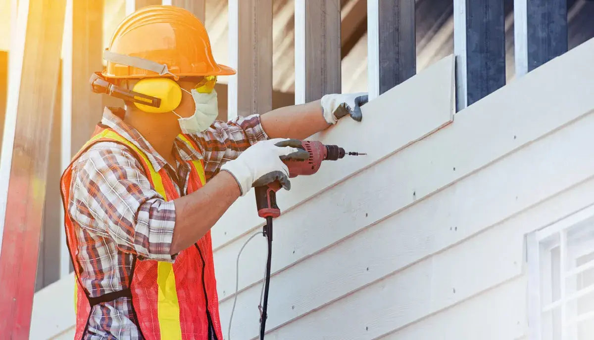 Trabajador construyendo edificio con materiales de construcción colombianos.