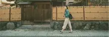 Mujer caminando en frente de casa asiática 