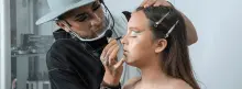 Maquillador profesional maquillando a una mujer 