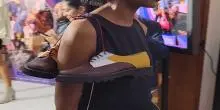 Persona con un par de zapatos en el el hombro 