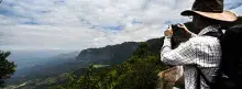Turista fotografiando paisaje con montañas en Colombia
