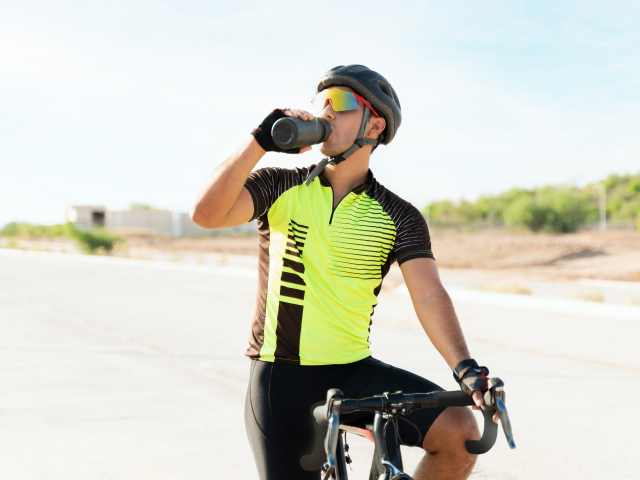 Ciclista usando ropa deportiva (gafas y casco para ciclismo).