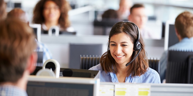 Joven ayuda a clientes en un centro de servicios BPO.